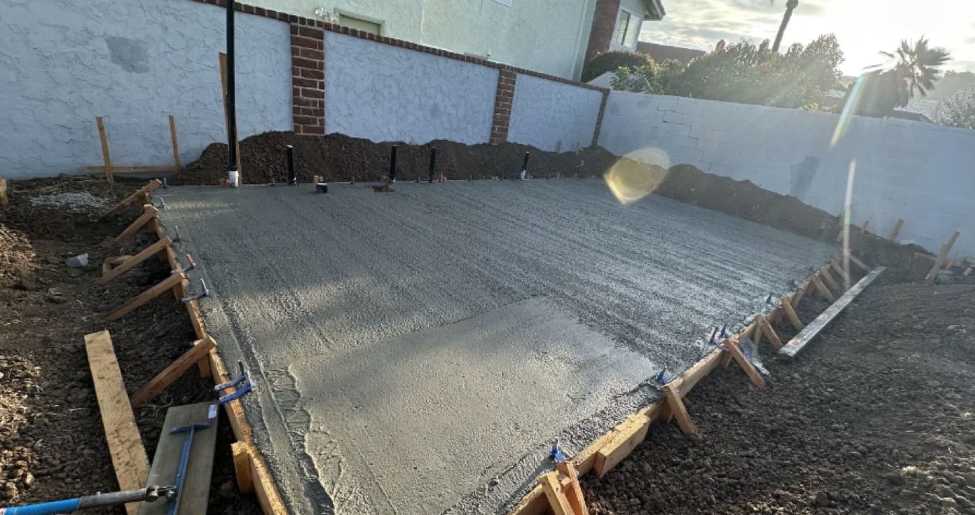 Fresh concrete being screeded and finished on an ADU slab pour in Orange County