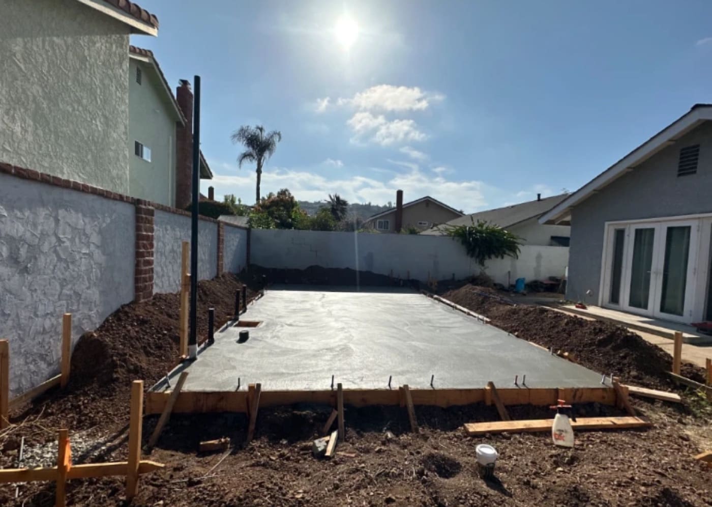 Finished ADU concrete slab foundation curing in a tight Orange County backyard