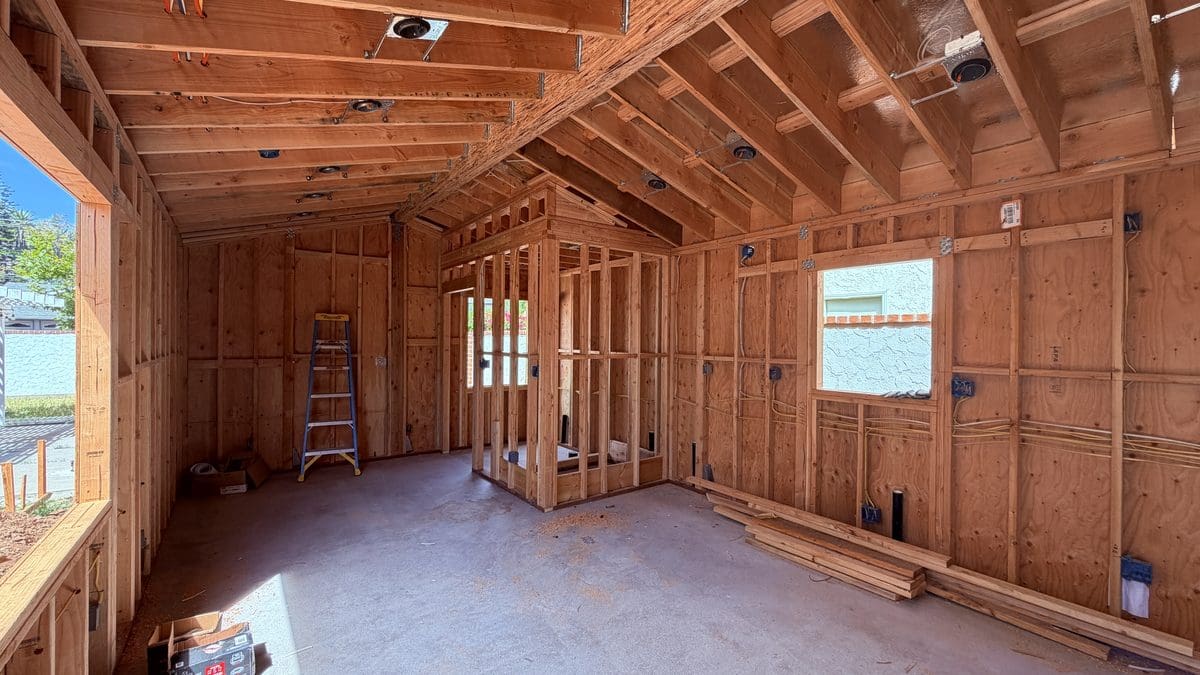 Completed wall and roof framing inside a new ADU in Orange, California, with interior partitions and rough electrical boxes, August 2026