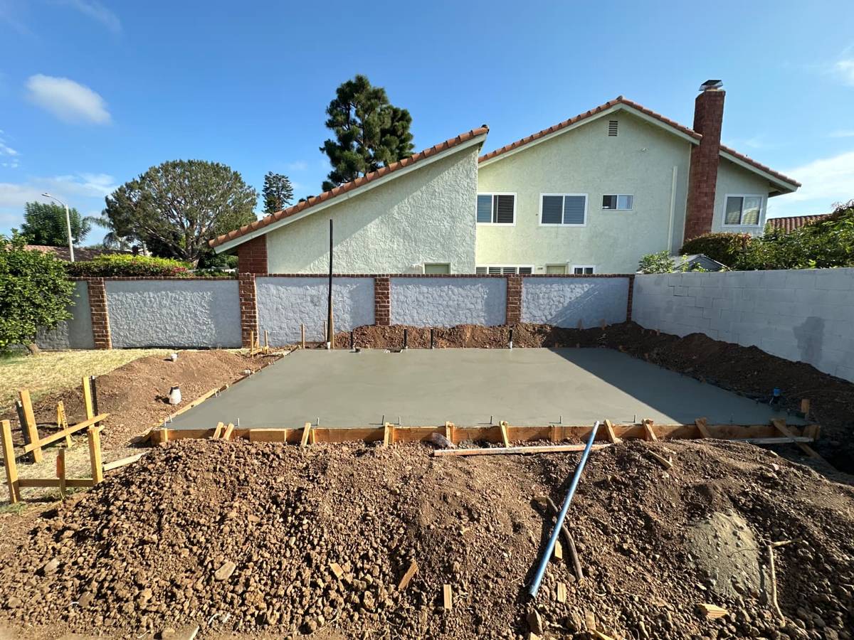Freshly poured concrete slab for a new detached ADU in a back yard in Orange, California, August 2026