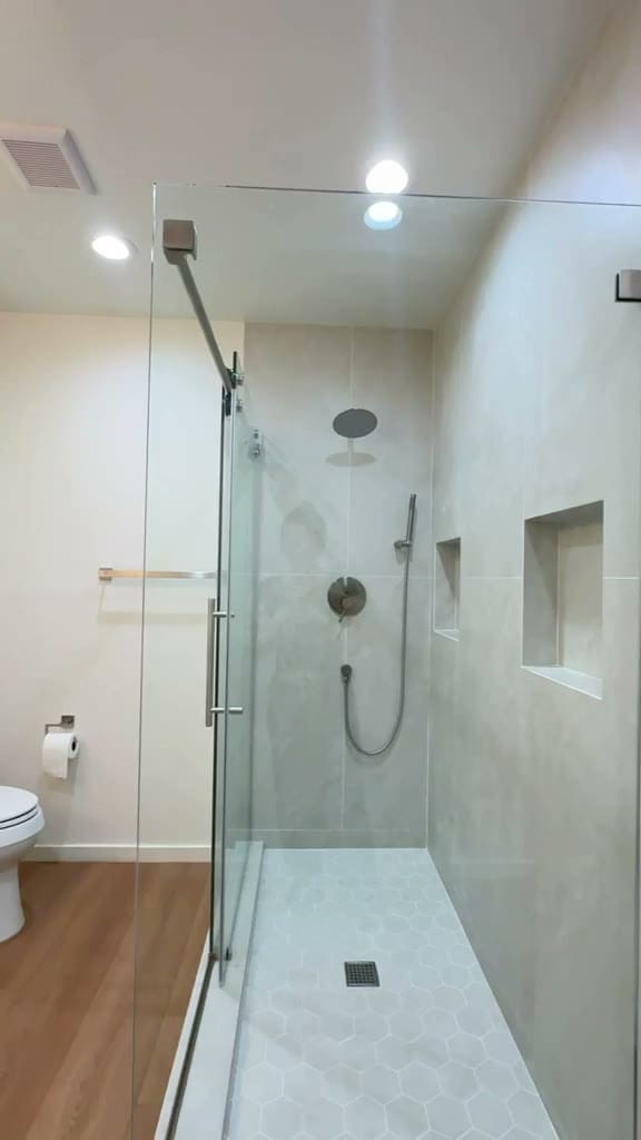 ADU bathroom with wood vanity, quartz top and frameless glass shower in Pasadena CA