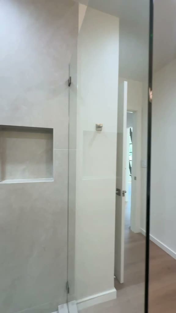 Rain shower with handheld, large-format tile, two recessed niches and hex tile floor in a Pasadena ADU