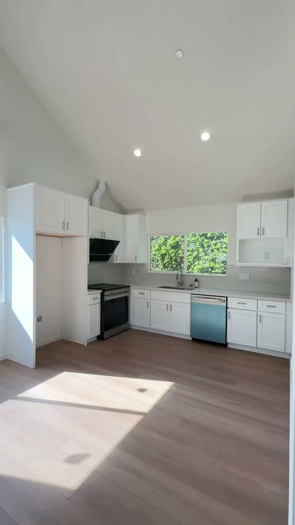 White shaker kitchen with quartz counters, stainless range and dishwasher under a vaulted ceiling in a Pasadena ADU