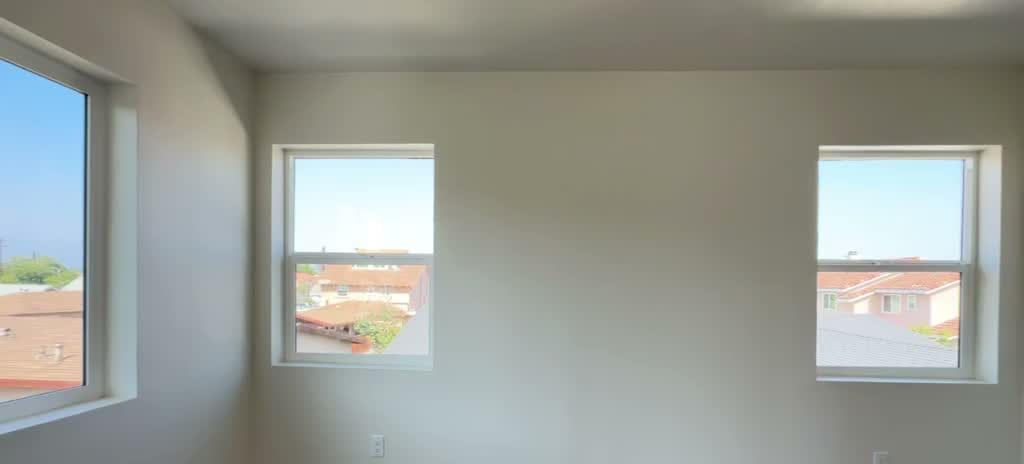 Second floor ADU bedroom with three windows framing San Gabriel mountain views in Rosemead CA