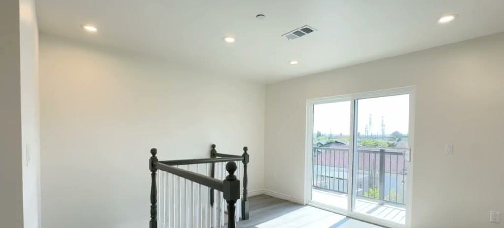 Second floor loft of a two-story ADU with balcony access through a sliding glass door